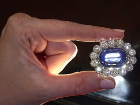 A staffer holds a sapphire and diamond owned by Napoleon’s adopted daughter Stephanie de Beauharnais during a preview at Christie’s before their auction sale, in Geneva, Switzerland, May 5, 2021.