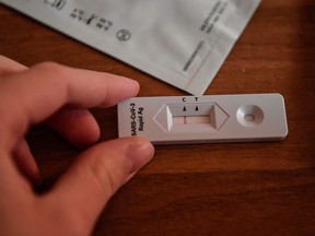 Asimina, a high school student, checks her negative Covid-19  test result after undergoing self testing at her home  on April 11, 2021.