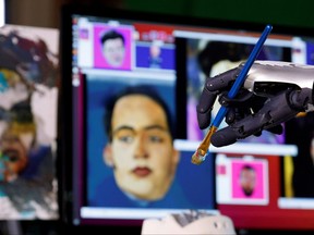 Sophia, a humanoid robot developed by Hanson Robotics, holds a paintbrush during a demonstration ahead of her NFT work being auctioned in Hong Kong. Tyrone Sioux/Reuters