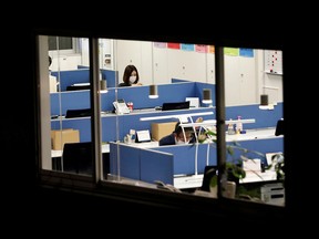 Office workers wearing protective masks, following the coronavirus outbreak, work at a business building in Tokyo, Japan November 27, 2020.