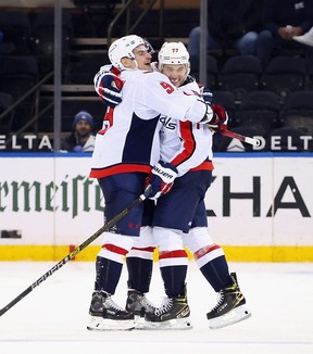 T.J. Oshie, right, embraces Dmitry Orlov after Oshie completed the hat trick against the Rangers on Wednesday night. Oshie’s father had passed away the day before. USA TODAY SPORTS