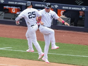 New York Yankees shortstop Gleyber Torres, left, celebrates with third base coach Phil Nevin after hitting a home run during the sixth inning against the Washington Nationals at Yankee Stadium in New York, May 9, 2021.