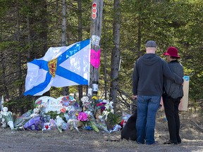A couple pays their respects at a roadblock in Portapique, N.S. on Wednesday, April 22, 2020.
