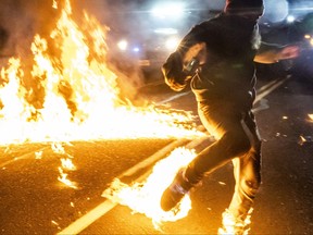 A protester, whose feet caught fire after a molotov cocktail exploded on him, runs toward a medic during a protest against police brutality and racial injustice on Sept. 5, 2020 in Portland, Oregon.