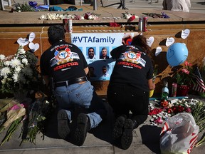 Mourners hang a poster at a memorial for the nine victims of a shooting at the Santa Clara Valley Transportation Authority (VTA) light rail yard on May 27, 2021 in San Jose, California.