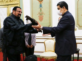 Venezuela's President Nicolas Maduro receives a samurai sword as a gift from actor Steven Seagal, who was visiting Venezuela as a representative of Russia, in Caracas, Venezuela May 4, 2021.