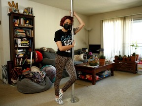 April Haze, a San Jose-based stripper, poses for a photo with her pole at her home April 15, 2021.