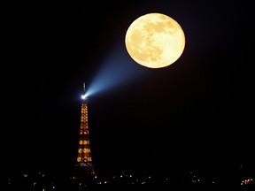 The full moon, known as the "Super Pink Moon" rises behind the Eiffel Tower last month.