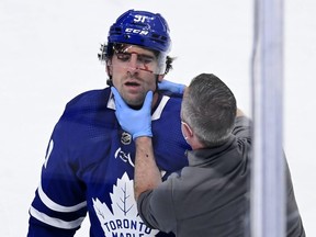 Maple Leafs centre John Tavares is examined by a trainer after an ugly collision in Game 1 of their series against Montreal. THE CANADIAN PRESS