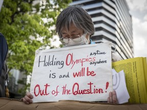 A protester holds a placard during a protest against the Tokyo Olympics on May 9, 2021 in Tokyo, Japan.