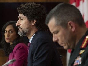 Public Services and Procurement Minister Anita Anand and Major General Dany Fortin look on as Prime Minister Justin Trudeau responds to a question during a news conference in Ottawa, Monday, Dec. 7, 2020.