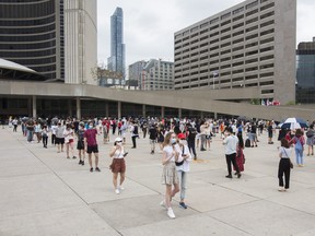 People in line for a pop-up vaccination clinic hosted by the City of Toronto and University Health Network at Nathan Philips Square in Toronto on Sunday, May 23, 2021.
