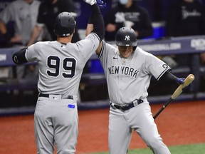 Aaron Judge, left, celebrates with Gio Urshela of the New York Yankees after hitting a solo home run during the first inning against the Tampa Bay Rays at Tropicana Field on May 11, 2021 in St Petersburg, Fla.