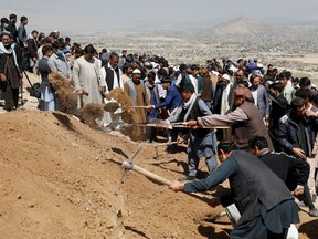Men dig graves for the victims of yesterday's explosion during a mass funeral ceremony in Kabul, Afghanistan May 9, 2021.