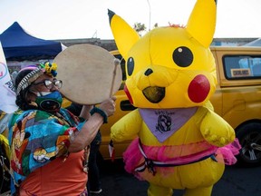 Leftist candidates for the Constituent Assembly for the Partido del Pueblo (People’s Party) Giovanna Grandon (R), known as Pikachu aunt, in a costume of the fictional Pokemon, with which she participated in social protests in 2019, and Mapuche indigenous Juanita Millal (L), visit a poor neighbourhood in Santiago on March 23, 2021.