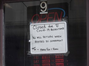 A sign in a barber shop window indicated the establishment was closed because of COVID-19 in Ottawa, Wednesday, March 18, 2020.