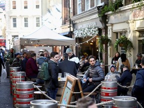 People drink at the terrace of a bar, as the coronavirus disease (COVID-19) restrictions ease, in London, Britain, April 16, 2021.