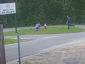 A knife-wielding man runs towards a girl Tuesday morning in Pensacola, Fla.