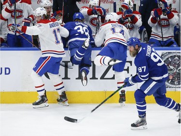 Montreal Canadiens Josh Anderson RW (17) and teammate Nick Suzuki (14) put Toronto Maple Leafs Rasmus Sandin D (38) into the bench during second period action in Toronto on Thursday May 6, 2021. Jack Boland/Toronto Sun/Postmedia Network