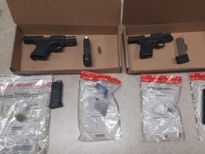 Drug Enforcement Unit officers allegedly seized these guns, ammunition and drugs while executing a search warrant at apartments near Simcoe St. N. and Rossland Rd. W. on Tuesday, May 11, 2021.