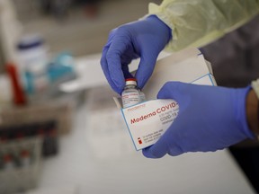 A health-care worker from Women's College Hospital prepare doses of the Moderna COVID-19 vaccine at a pop-up clinic in Toronto on April 17, 2021.