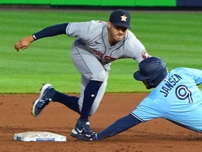 Danny Jansen of the Toronto Blue Jays is tagged out by Carlos Correa  of the Houston Astros trying to stretch a single into a double during the sixth inning at Sahlen Field on June 4, 2021 in Buffalo.