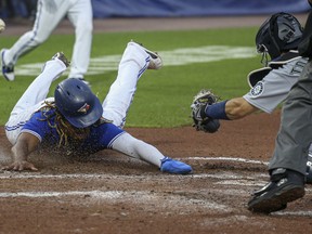 Vladimir Guerrero Jr. of the Toronto Blue Jays slides across the plate to score on a two-run RBI double by Randal Grichuk on Wednesday.