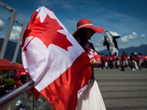A woman  waves a Canadian flag while sporting a patriotic outfit during Canada Day celebrations in Vancouver, on July 1, 2019.