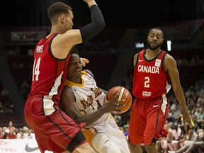 Team Virgin Islands' Georgio Milligan (4) tries to get through the defence of Team Canada's Dwight Powell (14) and Aaron Best (2) during FIBA World Cup qualifier action in 2018.