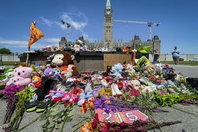 Residential schools memorial of shoes at the Centennial Flame on Parliament Hill in Ottawa on Monday, June 1, 2021 in memory of the 215 children whose remains were found on the grounds of the former Kamloops Indian Residential School in Kamloops, B.C.