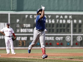 Blue Jays’ Vladimir Guerrero Jr. points to the heavens as he rounds third base yesterday at Fenway Park after becoming the first player in the majors to reach the 20-home run mark for the season. Vlad’s two-run blast in the first inning propelled the Blue Jays to a 7-2 victory over the Red Sox.