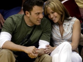 Ben Affleck gets a smile from girlfriend Jennifer Lopez during the Los Angeles Lakers-San Antonio Spurs NBA Western Conference semifinal in Los Angeles May 11, 2003.