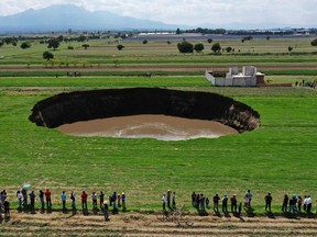 Aerial view of a sinkhole that was found by farmers in a field of crops in Santa Maria Zacatepec, state of Puebla, Mexico, on May 30, 2021.