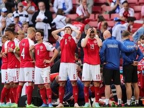 Denmark's players react as paramedics attend to Denmark's midfielder Christian Eriksen after he collapsed on the pitch during the UEFA EURO 2020 Group B football match between Denmark and Finland at the Parken Stadium in Copenhagen on June 12, 2021.