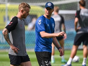 Denmark's coach Kasper Hjulmand (R) talks with Denmark's defender Simon Kjaer during their MD-1 training session at DBU Traeningsbane in Helsingor on June 20, 2021.