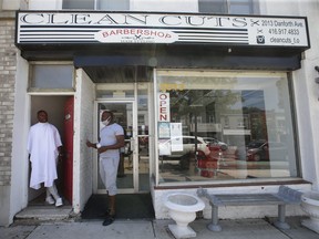 Inskip Redman (right), owner of Clean Cuts barber shop on Danforth Ave. west of Woodbine Ave., talks outside his shop before cutting the hair of one of his best clients and friends, John Robinson Jr., on his rear outside rooftop deck on Thursday, June 17, 2021.