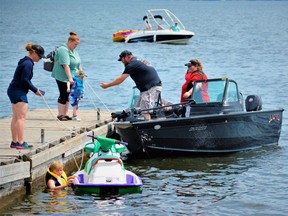 A little boy seems a bit reticent to come aboard despite urging from patient family members gathered on the dock of the Herchimer boat launch in Belleville, Ont., Friday, June 4, 2021.