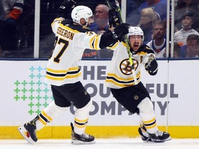 Bruins forward Brad Marchand, right, celebrates with teammate Patrice Bergeron after scoring the game-winning goal in overtime against the Islanders in Game 3 of the second round of the 2021 NHL Stanley Cup Playoffs at Nassau Coliseum in Uniondale, N.Y., Thursday, June 3, 2021.