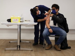 A man receives a dose of Pfizer/BioNTech COVID-19 vaccine during a vaccination campaign inside the University of Santiago, Chile June 30, 2021.