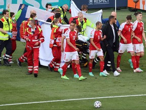 Denmark's players gather as paramedics attend to midfielder Christian Eriksen (not seen) during the UEFA EURO 2020 Group B football match between Denmark and Finland at the Parken Stadium in Copenhagen on June 12, 2021.