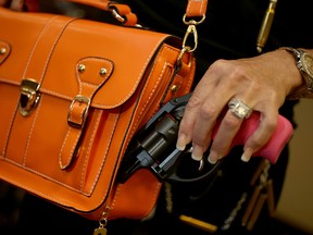 Susan Kushlin poses with a concealed-carry handbag that her company, Gun Girls, Inc., created for women that enjoy guns on October 21, 2013 in Boca Raton, Florida.