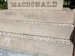 Numbered hearts are placed on the steps of the Sir John A. MacDonald statue in Kingston, Ont., on Monday, May 31, 2021. The hearts represent the 215 remains of children that were found on the grounds of a former residential school in Kamloops last week.