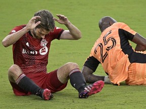 Toronto FC forward Patrick Mullins (left) reacts after missing a shot on goal in front of FC Cincinnati goalkeeper Kenneth Vermeer during the first half of an MLS soccer match, Saturday, June 26, 2021, in Orlando, Fla.