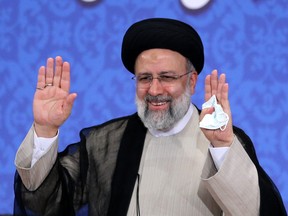 Iran's President-elect Ebrahim Raisi smiles as he greets media representatives during his first press conference in Tehran on June 21, 2021.