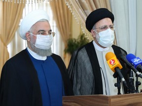 A handout picture provided by the Iranian presidency on June 19, 2021, shows outgoing President Hassan Rouhani (left) taking in part in a press conference with President-elect Ebrahim Raisi during his visit to congratulate the ultraconservative cleric on winning the presidential election.