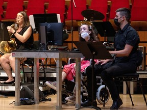 Alexandra Kerlidou, 21, who suffers from cerebral palsy, plays the "Eyeharp” next to computer scientist Zacharias Vamvakousis, during a concert in Athens, Greece, June 14, 2021.
