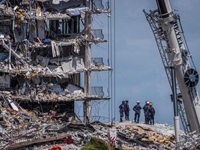 Members of the South Florida Urban Search and Rescue team look for possible survivors in the partially collapsed 12-story Champlain Towers South condo building in Surfside, Fla., Sunday, June 27, 2021.
