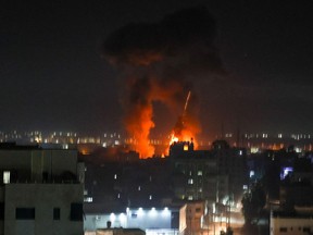 Explosions light up the night sky above buildings in Gaza City as Israeli forces shell the Palestinian enclave, early on Wednesday, June 16, 2021.