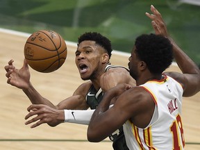 Giannis Antetokounmpo of the Milwaukee Bucks is pressured by Solomon Hill of the Atlanta Hawks during the fourth quarter in game one of the Eastern Conference Finals at Fiserv Forum on June 23, 2021 in Milwaukee, Wis.
