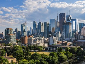 Downtown Toronto skyline: financial district skyscrapers with  blue cloudy sky in the background and a park at the bottom